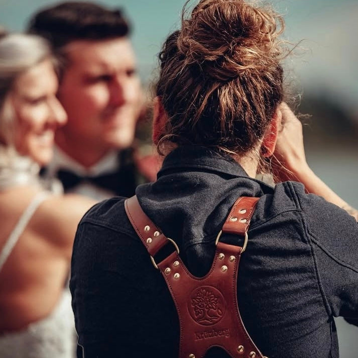Fotografin mit handgefertigtem Leder-Kameragurt bei einer Hochzeit – stilvoll und bequem.